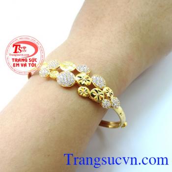 Chiếc vòng tay đính đá lung linh khắc cách hoa theo hình vòng cung thể hiện sự tươi trẻ và nét đẹp rạng ngời của người phụ nữ. Vòng vàng đính đá lung linh